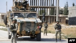 FILE - Turkish soldiers patrol the northern Syrian Kurdish town of Tal Abyad, on the border between Syria and Turkey, Oct. 23, 2019.
