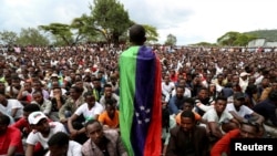 FILE - A Sidama youth leader carrying a flag addresses people as they gather for a meeting to declare their own region in Hawassa, Ethiopia, July 17, 2019. 