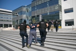 FILE - Kosovo police escort a suspect in a terror plot to a court in Pristina, July 12, 2015. Police had arrested five suspects linked to the Islamic State group who allegedly were planning to poison a reservoir.