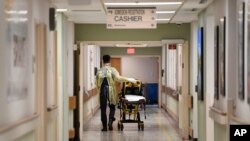 FILE - A Prince George County firefighter walks the halls of Laurel Medical Center in Laurel, Md., April 17, 2020. 