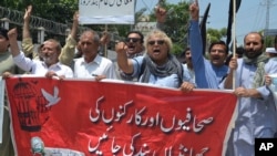 FILE - Pakistani journalists denounce censorship, holding a banner that reads: "stop sacking journalists," in Peshawar, Pakistan, July 16, 2019. 