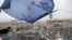 FILE - A supporter waves a European Union flag from a building top in Kyiv, Nov. 29, 2013.
