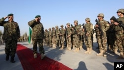 FILE - General Sher Mohammad Karimi, chief of staff of the Afghan army, second left, salutes soldiers during a ceremony in Laghman province, east of Kabul, Afghanistan, Jan. 11, 2015.