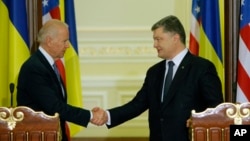 U.S. Vice President Joe Biden (L) and Ukrainian President Petro Poroshenko shake hands after a joint press conference in Kyiv, capital of Ukraine, Dec. 7, 2015.