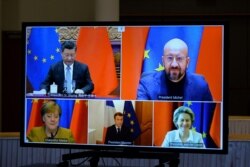 FILE - European Commission President Ursula von der Leyen, European Council President Charles Michel, German Chancellor Angela Merkel, French President Emmanuel Macron and Chinese President Xi Jinping meet remotely, in Brussels, Dec. 30, 2020.