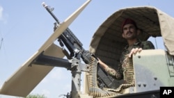 FILE - An Afghan National Army soldier stands guard in his vehicle in Camp Khogyani in Nangarhar province, east of Kabul — a region where homegrown militants loyal to the Islamic State group have made some inroads, Aug. 5, 2015.