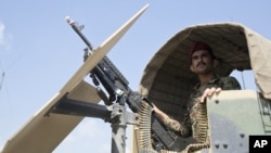 FILE - An Afghan National Army soldier stands guard in his vehicle in Camp Khogyani in Nangarhar province, east of Kabul — a region where homegrown militants loyal to the Islamic State group have made some advances, Aug. 5, 2015.