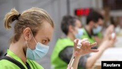Medical workers prepare doses of Oxford/AstraZeneca's COVID-19 vaccine at a vaccination center in Antwerp, Belgium, March 18, 2021. 