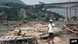 A man stands on a broken bridge at a flood-affected area following heavy rains in and around Beijing on Aug. 3, 2023.