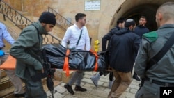 Israeli security personnel and members of Zaka Rescue and Recovery team carry the body of a Palestinian man who was fatally shot by Israeli police after he killed one Israeli and wounded four others in a shooting attack in Jerusalem's Old City, Sunday, No