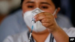 A nurse prepares a syringe with the Moderna COVID-19 vaccine at a temporary hospital in Guatemala City, Feb. 25, 2021. 