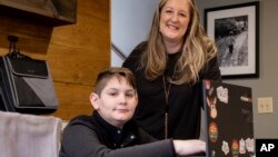 Kelli Rivera is photographed with her son Tate, 11 at their home in Roswell, Ga., Friday, Feb. 12, 2021. Rivera is hoping a voucher bill passes that will help pay for her to move her son out of a public Cobb County school and into a private school. (AP Photo/Ben Gray)