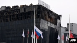 A Russian national flag flutters at half-staff in front of the Crocus City Hall in Krasnogorsk, suburban Moscow, on March 29, 2024, a week after a deadly attack by gunmen on the concert hall. U.S. officials say that the Islamic State-Khorasan was behind the rampage.