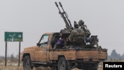 A rebel fighter sits on the back of a vehicle near Homs, Syria, after insurgents pressed their lightning advance on Dec. 7, 2024, saying they had seized most of the south, as government forces dug in to defend the key central city of Homs.