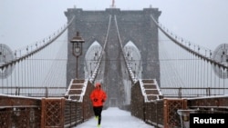 A man runs over the Brooklyn Bridge during morning snow in Manhattan, New York City, Dec. 17, 2016. 