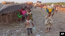 A child (r) carries food stuff on her head that she and other family children try to sell by walking from market area to market area in Kinshasa, Democratic Republic of Congo, May 28, 2014.