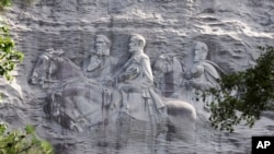 FILE - This June 23, 2015, file photo shows a carving depicting Confederate Civil War figures Stonewall Jackson, Robert E. Lee and Jefferson Davis, in Stone Mountain, Ga. The sculpture is America's largest Confederate memorial. 