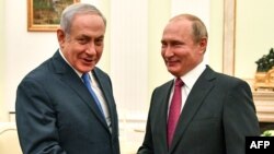 Russian President Vladimir Putin, right, shakes hands with Israeli Prime Minister Benjamin Netanyahu during their meeting at the Kremlin in Moscow, July 11, 2018.