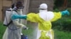 In this photo taken Sept. 9, 2018, a health worker sprays disinfectant on his colleague after working at an Ebola treatment centre in Beni, Eastern Congo.