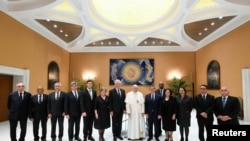 El Papa Francisco, al centro, posa con el mandatario cubano (iz.) Miguel Díaz-Canel y una amplia delegación del gobierno de Cuba, en el Vaticano, el 20 de junio de 2023.