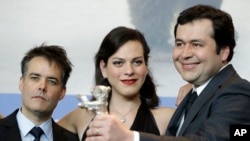 From left, director Sebastian Lelio, actress Daniela Vega and writer Gonzalo Maza pose for the photographers with their Best Screenplay silver bear for the film "A Fantastic Woman" during the award winners press conference at the 2017 Berlin International