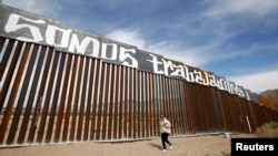 A group of activists paints the U.S.-Mexico border wall between Ciudad Juarez and New Mexico as a symbol of protest against U.S. President Donald Trump&#39;s new immigration reform in Ciudad Juarez, Mexico, Feb. 26, 2017. The paint reads &quot;We are workers.&quot;