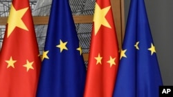 Bendera Uni Eropa dan China terlihat di salah satu gedung di Brussels. China mengatakan kebijakan ekspor Uni Eropa terhadap Beijing “tidak masuk akal." (Foto: melalui AP)
