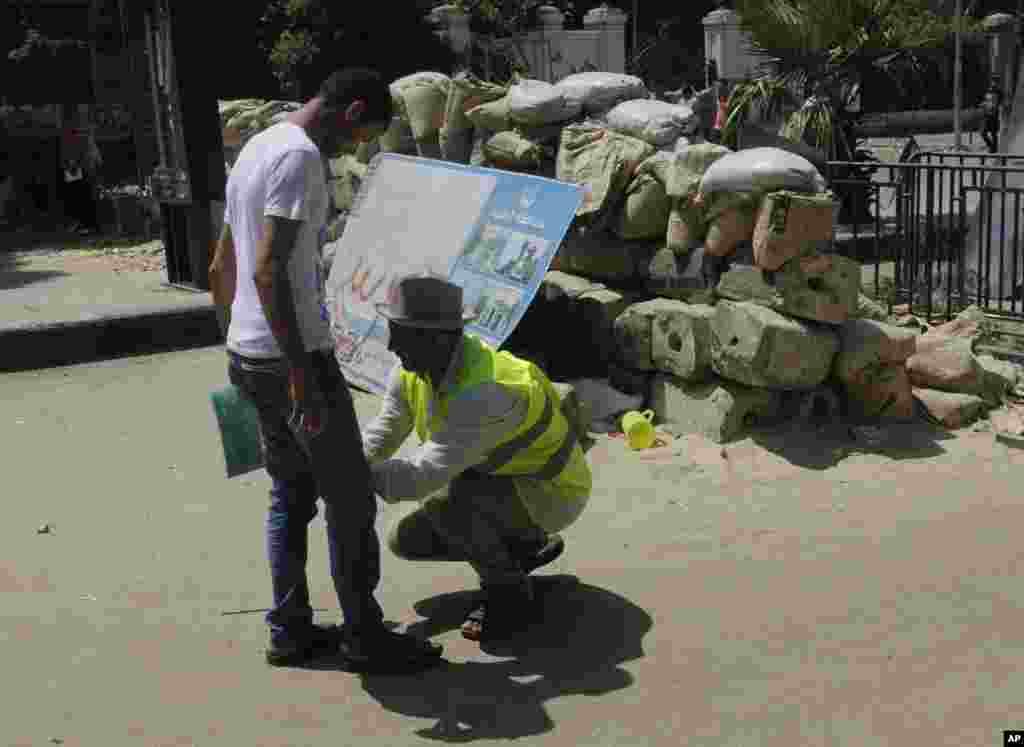 A security volunteer checks a supporter of Egypt's ousted President Mohamed Morsi as he enters Nahda Square, Cairo, August 12, 2013.