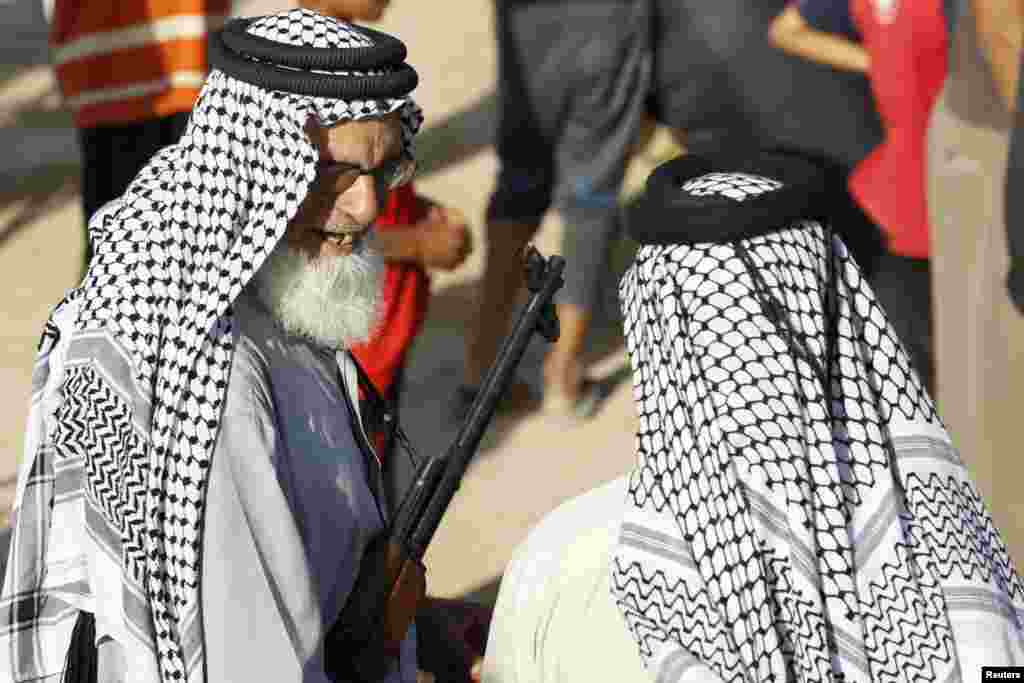 A volunteer who joined the Iraqi Army to fight the Islamic State of Iraq and the Levant holds a weapon during a parade in Al-Fdhiliya district, eastern Baghdad, June 15, 2014.