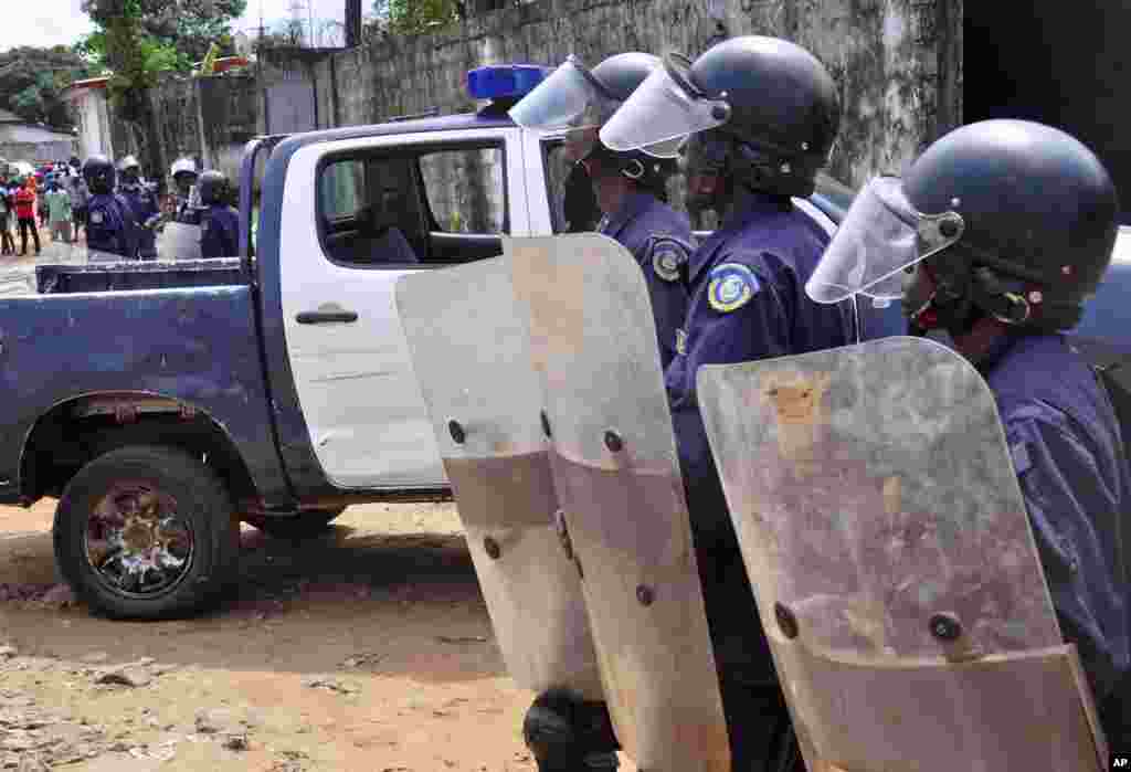 Liberian policemen dressed in riot gear disperse a crowd of people that blocked a main road after the body of someone suspected of dying from the Ebola virus was left in the street by health workers, Monrovia, Liberia, Aug. 14, 2014.