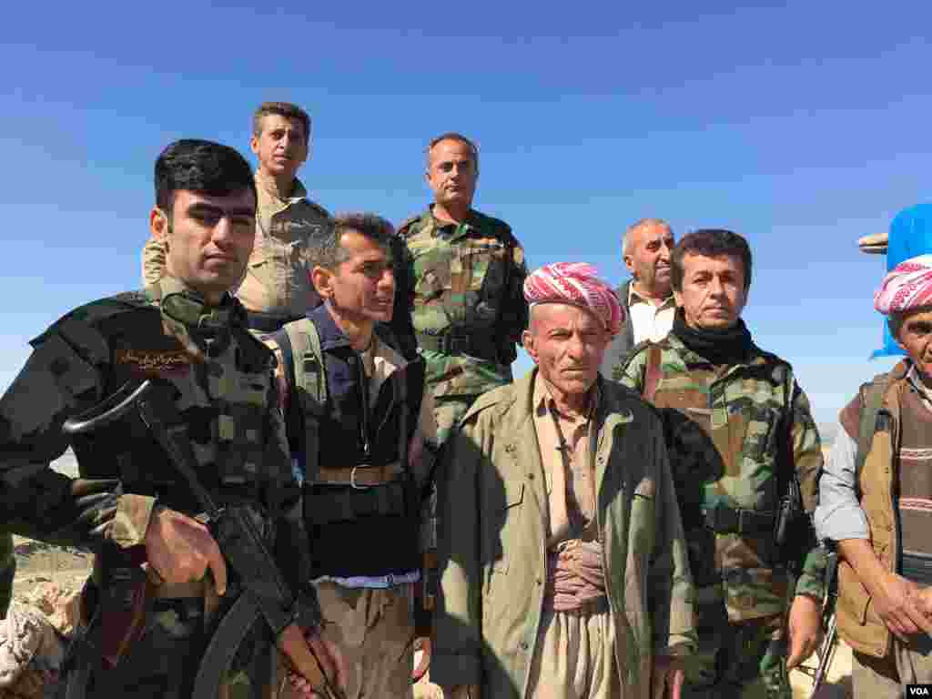 Elder Peshmerga fighter and now a volunteer, Omar Mirhan stands with his fellow Peshmerga on a hill overlooking the area of Makhmour which the Peshmerga won back from Islamic State in 2014, March 8, 2016. (S. Behn/VOA)