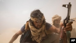 Tentara Yaman yang didukung oleh koalisi pimpinan Saudi naik di belakang kendaraan lapis baja saat mereka meninggalkan garis depan Marib, Yaman, 19 Juni 2021. (Foto: AP)