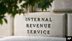 FILE - A sign outside the Internal Revenue Service building is seen, May 4, 2021, in Washington. Tax Day reveals a major split in how Joe Biden and Donald Trump would govern. 