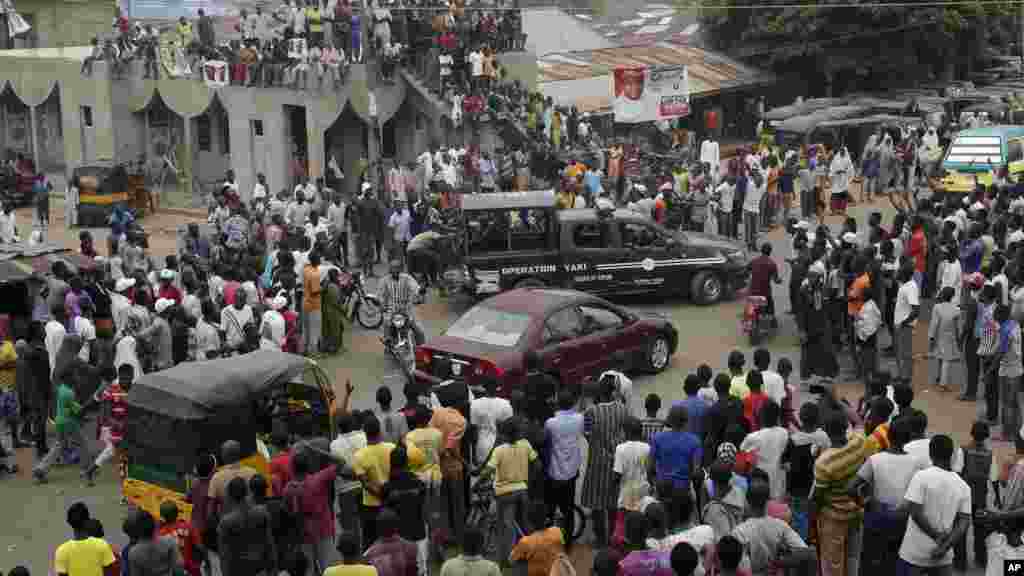 'Yan Najeriya dauke da tsintsiya da ruwa, Kaduna, Afrilu 1, 2015.