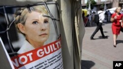 People walk past a tent camp in support of former Ukrainian Prime Minister Yulia Tymoshenko in Kiev, July 20, 2012.