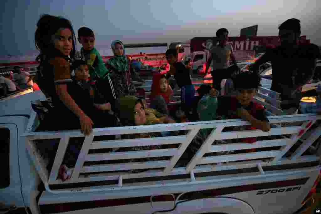 Fleeing Iraqi citizens from Mosul and other northern towns sit in a pick up truck between Mosul and Irbil, northern Iraq, June 25, 2014. 
