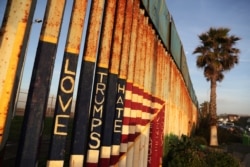 A message and the colors of the U.S. flag are seen on the U.S. and Mexico border fence at Friendship Park in Tijuana.