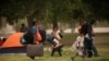 Mexicans camping near the Cordova-Americas international border crossing bridge while waiting to apply for asylum to the U.S., gather their belongings as they are moved to a shelter due a storm forecast, in Ciudad Juarez, Sept. 30, 2019.