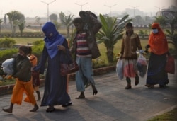 Rohingya refugees walk with their belongings to board a naval vessel to be relocated to to the island of Bhasan Char, in Chattogram, Bangladesh, Jan. 30, 2021.