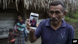 Domingo Caal Chub, de 61 años, muestra una fotografía de su nieta, Jakelin Amei Rosmery Caal Maquín, en Raxruhá, Guatemala.