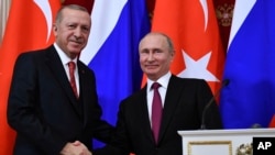 Russian President Vladimir Putin, right, shakes hands with Turkey's President Recep Tayyip Erdogan after their joint news conference following the talks in the Kremlin in Moscow, Russia, Jan. 23, 2019. 