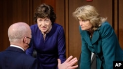 Homeland Security Secretary Alejandro Mayorkas, left, talks with Sen. Susan Collins, R-Maine, center, and Sen. Lisa Murkowski, R-Alaska, right, during a break of the Senate Appropriations committee hearing to examine domestic extremism, May 12, 2021.