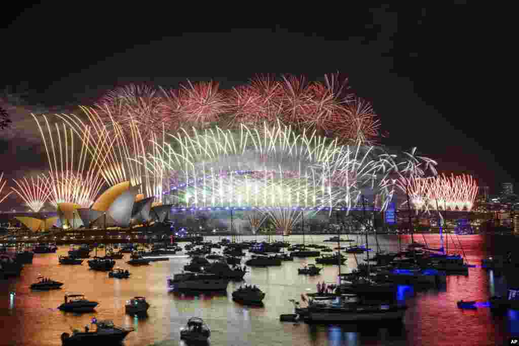 Fogos de artifício rebentam na Ópera de Sydney e na Harbour Bridge durante as celebrações da véspera de Ano Novo em Sydney, Austrália, a 31 de dezembro de 2024.