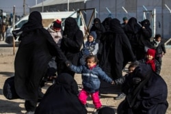 FILE - Women and children are seen in the Kurdish-run al-Hol camp, which holds suspected relatives of Islamic State group fighters, in Hasakah governorate in northeastern Syria, Jan. 28, 2021.