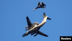 FILE - Russian Air Force Beriev A-50 early warning aircraft and Sukhoi Su-27 jet fighter fly in Kaliningrad, Russia, Apr. 25, 2020.