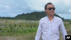 FILE - Khin Nyunt, a local shop owner, stands near the terminal of a gas pipeline to the Bay of Bengal in Kyaukpyu in the Rakhine region, Myanmar, Oct. 5, 2016. China’s big development plans for the town appear to hold few opportunities for local residents.