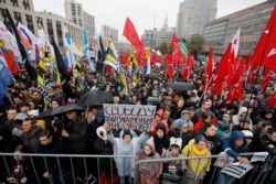 FILE - A protester holds a banner reading "Freedom to political prisoners!" during a rally in Moscow, Russia, Sept. 29, 2019.