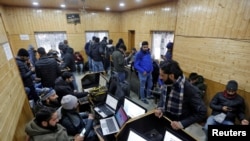 Journalists use the internet as they work inside a government-run media center in Srinagar, Jan. 10, 2020.
