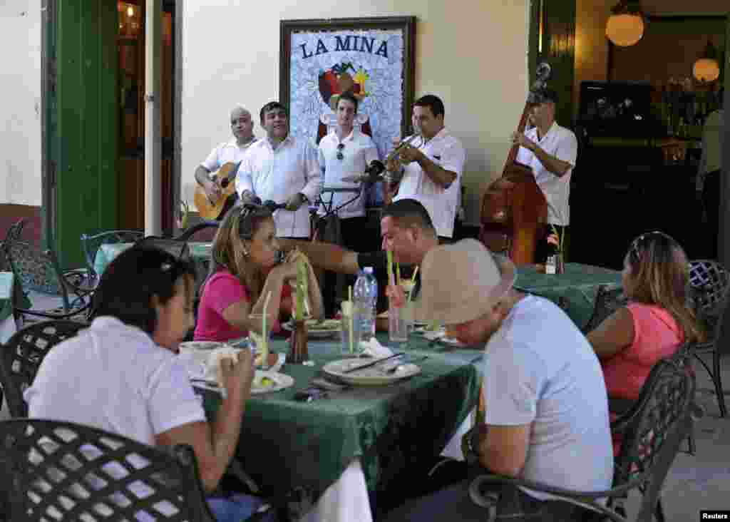 Para musisi tampil menghibur turis di restoran &quot;La Mina&quot; di Old Havana, Kuba (18/12).(Reuters/Enrique De La Osa)
