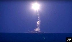 In this photo made from the footage taken from Russian Defense Ministry official website, a Russian navy ship on the Caspian Sea launches a cruise missile toward Islamic State targets in Syria, the ministry said, Oct. 7, 2015.